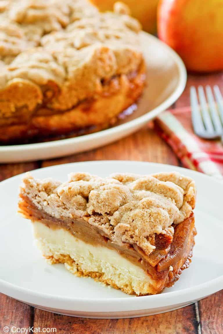 a slice of apple coffee cake with crumb topping on a plate.