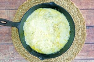 cheesy au gratin potatoes in a skillet before baking.