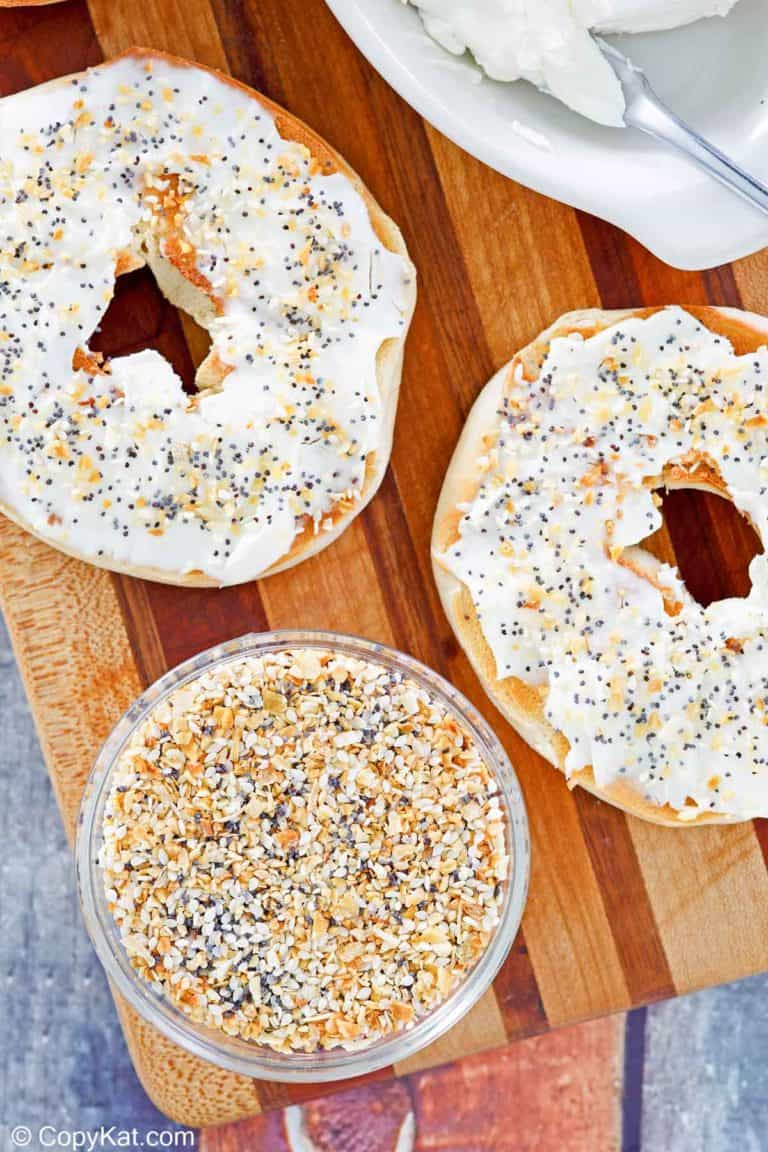 a bowl of homemade everything bagel seasoning and a bagel with cream cheese.
