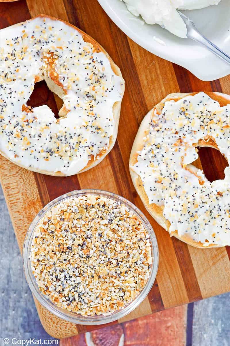 a bowl of homemade everything bagel seasoning and a bagel with cream cheese.