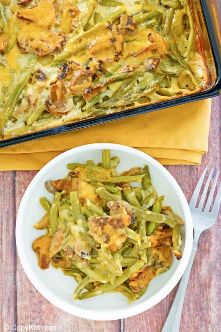 overhead view of green bean casserole with cheese in a baking dish and on a plate.