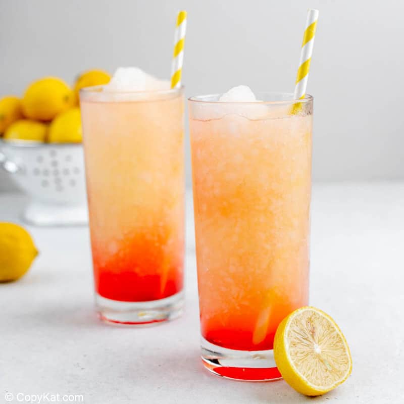 two homemade McDonald's frozen strawberry lemonade drinks and fresh lemons.