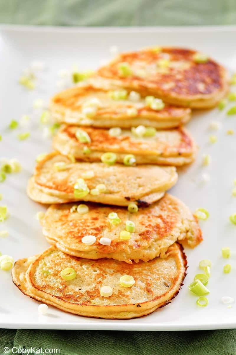 six mashed potato pancakes on a platter.