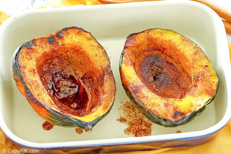 microwave acorn squash with butter brown sugar sauce in a serving dish.