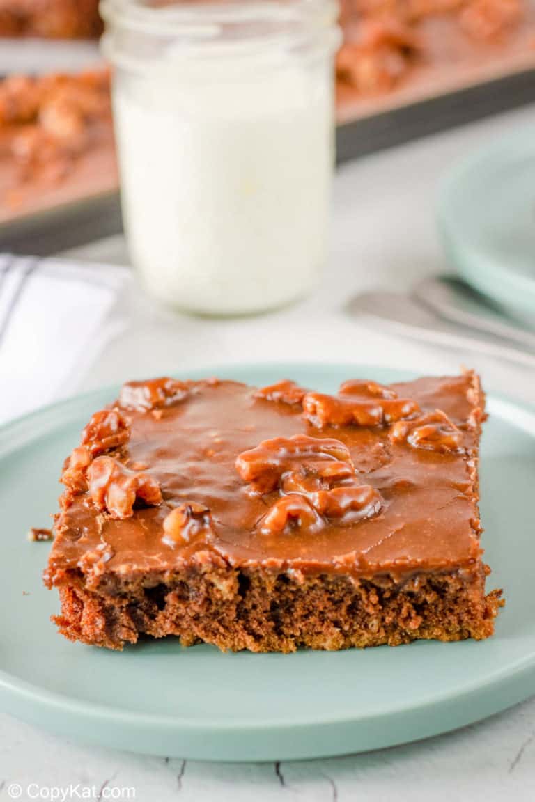 Texas sheet cake slice on a plate and a glass of milk.