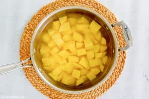 yukon gold potato cubes and water in a pan.