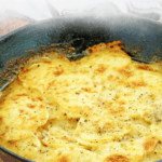 au gratin potatoes in an iron skillet