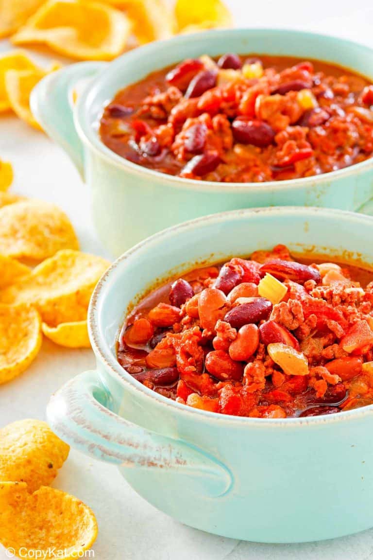 two bowls of crockpot chili and corn chips.