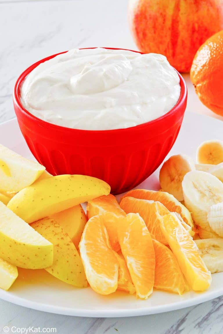 fruit dip in a bowl and various fresh fruit next to it.