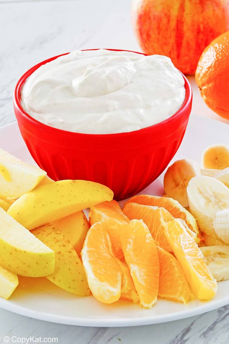 fruit dip in a bowl and various fresh fruit next to it.