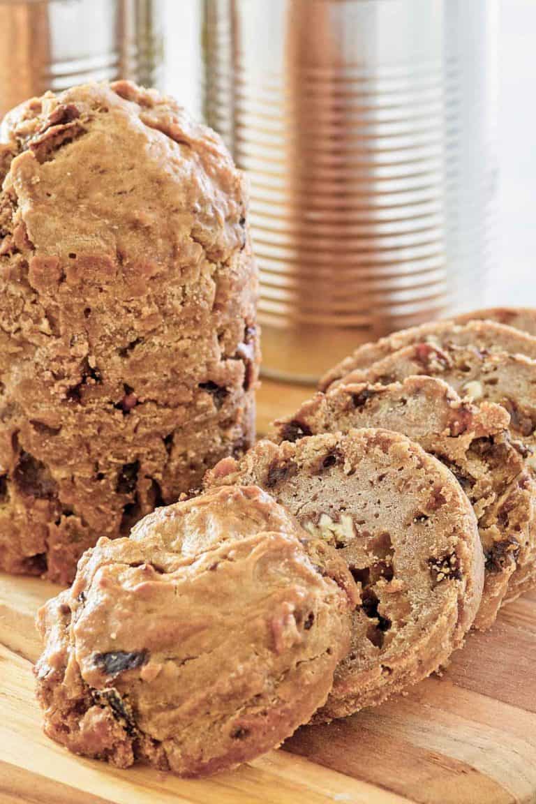 two loaves of Boston brown bread and one is sliced.