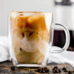 cold brew coffee with cream in a clear coffee mug.