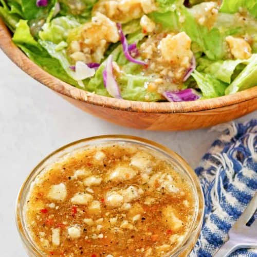homemade Outback blue cheese vinaigrette dressing in a small bowl and on a salad.