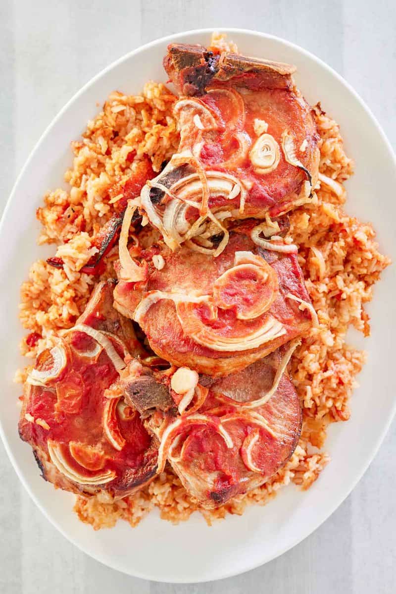 overhead view of baked pork chops and rice on a platter.