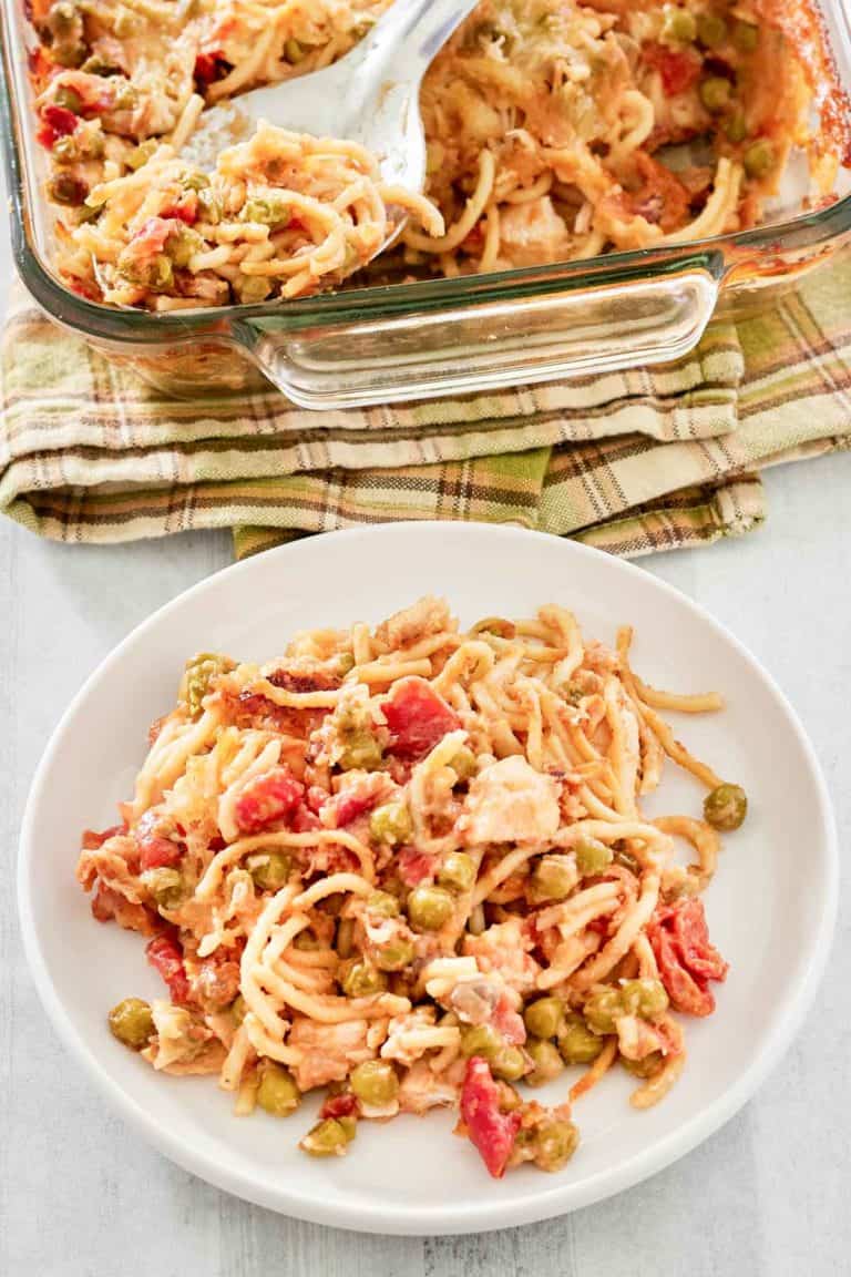 chicken spaghetti casserole on a plate and glass baking dish.