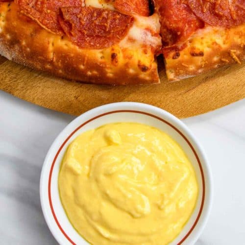 bowl of homemade Papa John's garlic sauce and a pizza.