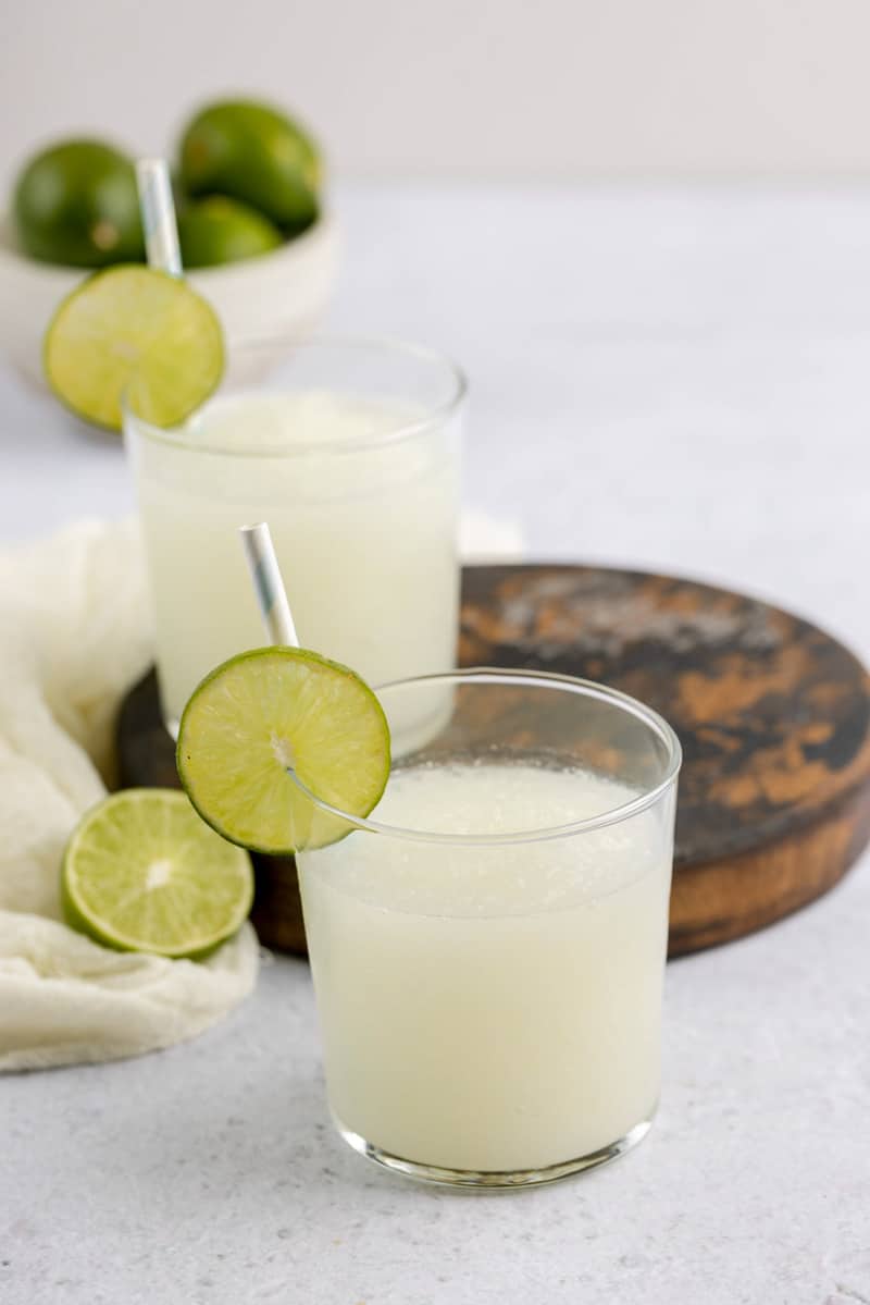 glasses of copycat Taco Bell pina colada frutista freeze and limes.
