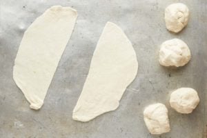 samosa dough balls rolled and cut in half.
