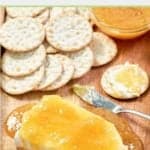 jezebel sauce over cream cheese and crackers on a tray.