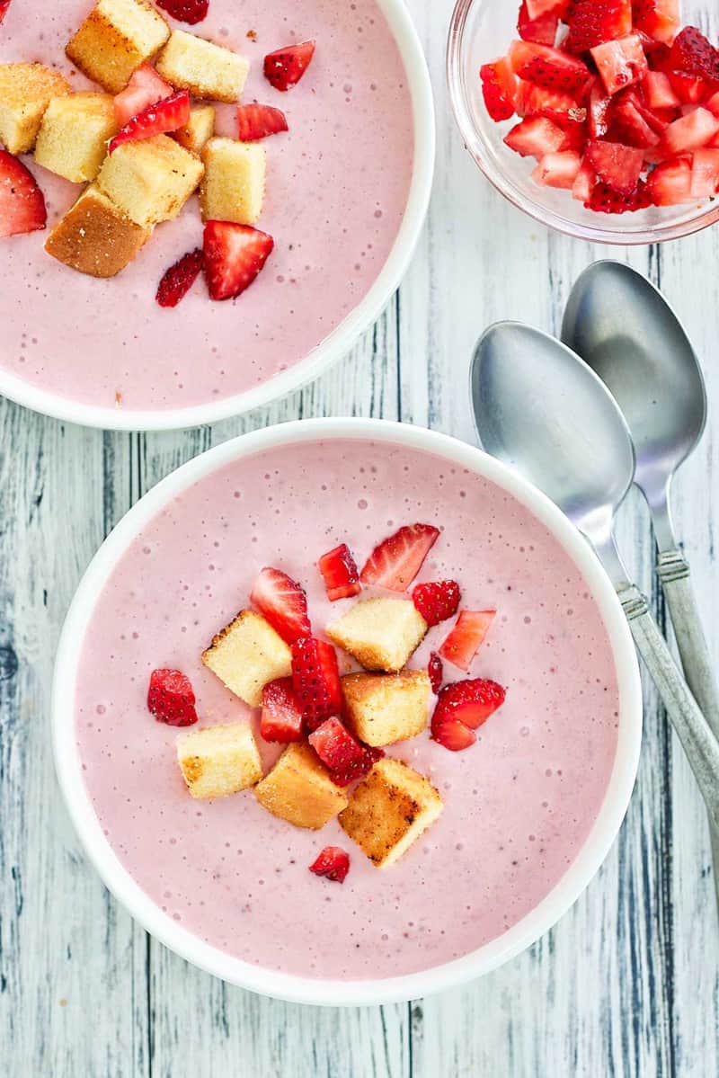 overhead view of strawberry soup with pound cake croutons.