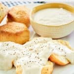 homemade Cracker Barrel sawmill gravy in a bowl and on biscuits.