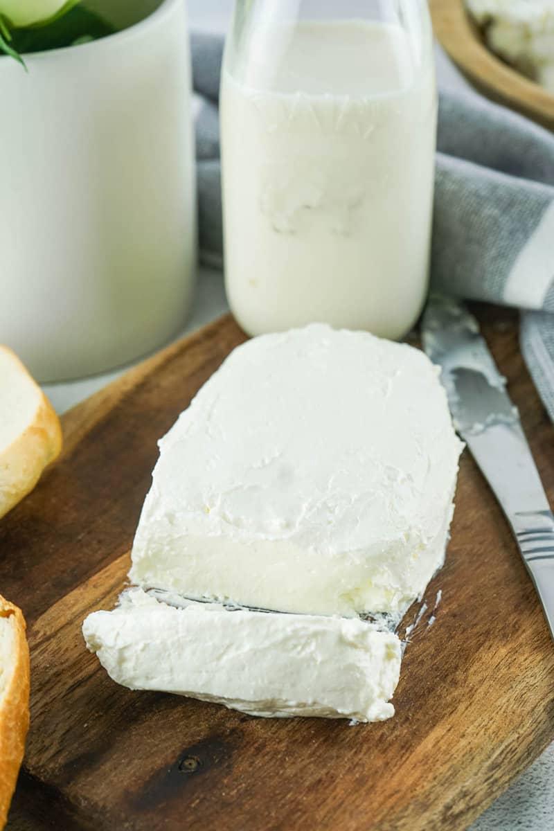 block of homemade cream cheese and a glass bottle of half and half.