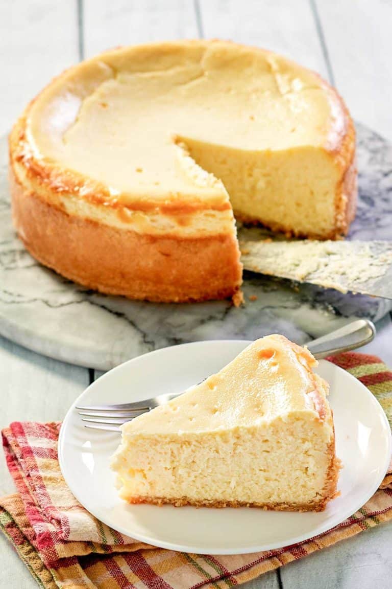 copycat Lindy's New York Cheesecake on a platter and a slice in front of it.
