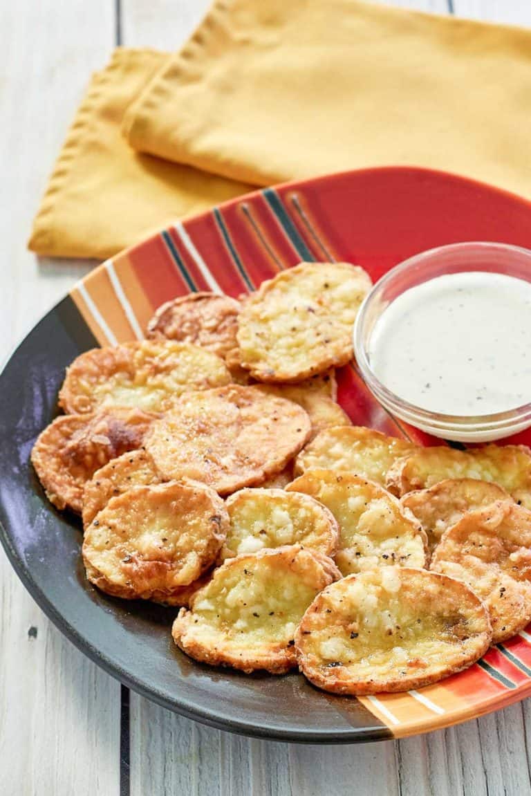 fried mojo potatoes and dipping sauce on a platter.