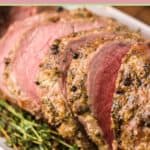 sliced smoked eye of round roast and herbs on a platter.