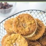 oatmeal raisin muffins in a basket and bowl of raisins in the background.
