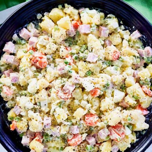 overhead view of olivier salad in a black serving bowl.