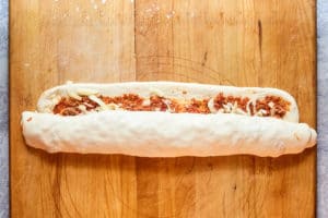 pizza rolls dough and filling rolled into a log.