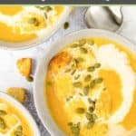 bowls of pumpkin bisque topped with croutons and pepitas.