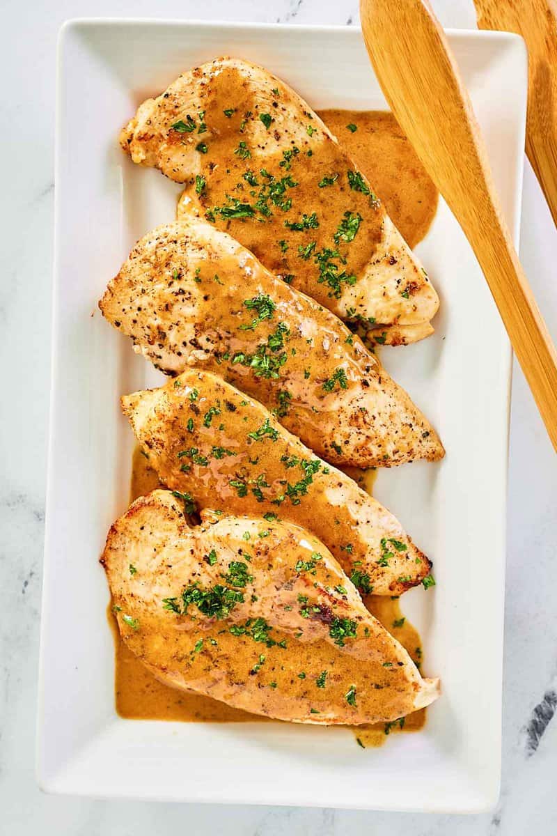 overhead view of chicken dijon and sauce on a platter.
