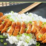 chicken katsu with sauce over white rice.
