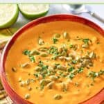 bowl of pumpkin curry soup topped with pepitas.