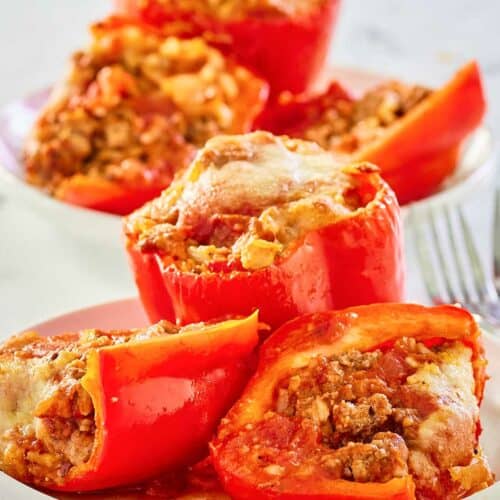stuffed bell peppers with rice and meat on plates.