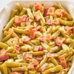 homemade Texas Roadhouse green beans in a beige serving dish.