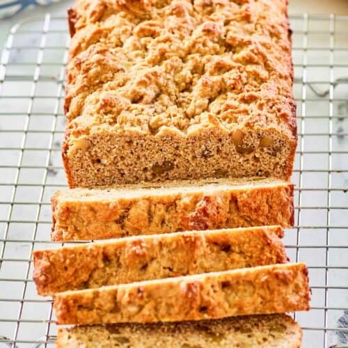 whole wheat banana nut bread slices on a wire rack.