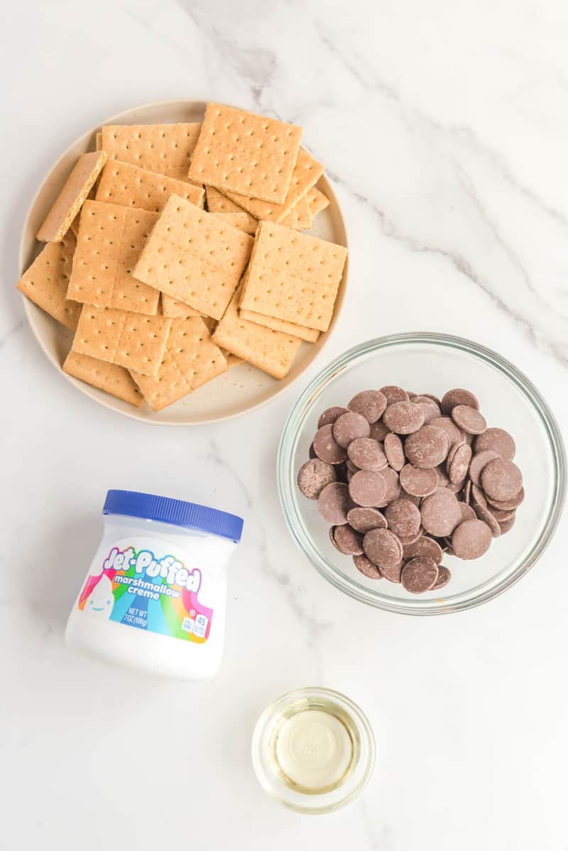 Ingredients for S'mores cookies: graham crackers, chocolate wafers, marshmallow creme, and vegetable oil.