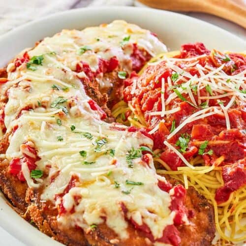 copycat Olive Garden eggplant parmigiana, pasta, and marinara on a platter.