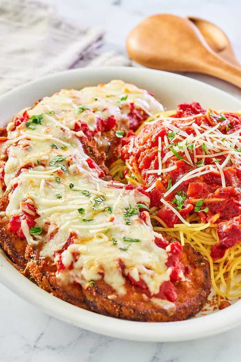 copycat Olive Garden eggplant parmigiana, pasta, and marinara on a platter.