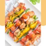 Overhead view of air fryer chicken kabobs on a square white plate.
