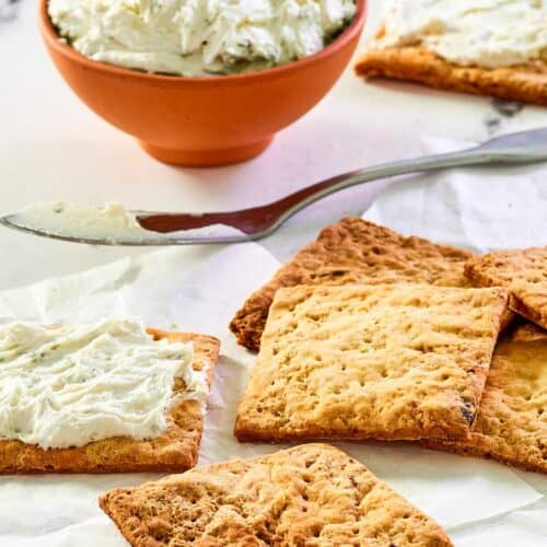 Homemade crackers and a bowl of a cheese spread.