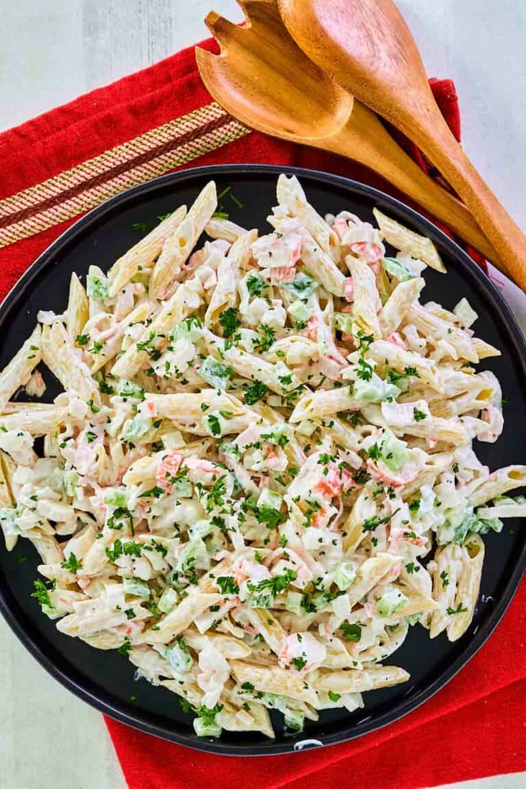 Overhead view of seafood pasta salad on a black plate.