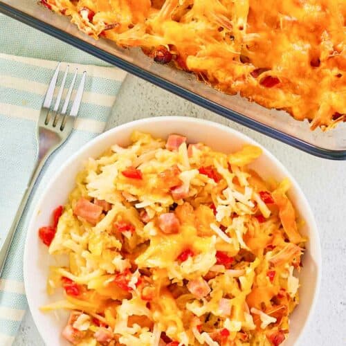 Overhead view of cheesy hash brown casserole in a baking dish and on a plate.