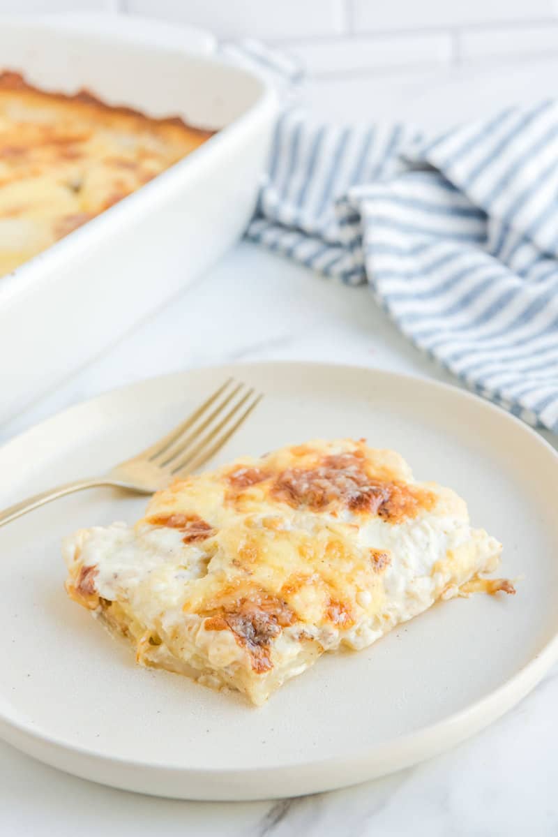 Potato au gratin on a plate and in a baking dish.
