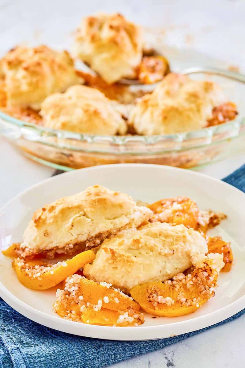 Bisquick peach cobbler on a plate and in a pie plate.