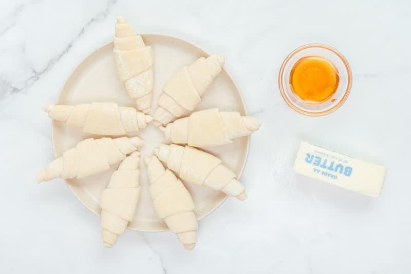 Copycat Cheddar's honey butter croissants ingredients on a marble surface.