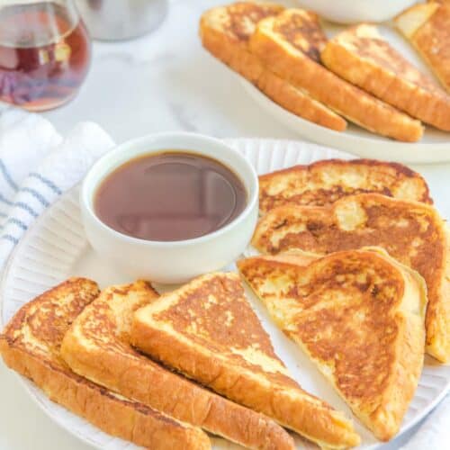 Copycat Cracker Barrel French toast and a bowl of syrup on a plate.